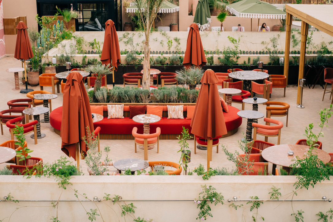 Interior of a luxurious Moroccan restaurant with intricate tilework, hanging lanterns, plush seating, and a warm, inviting ambiance, authentic decor