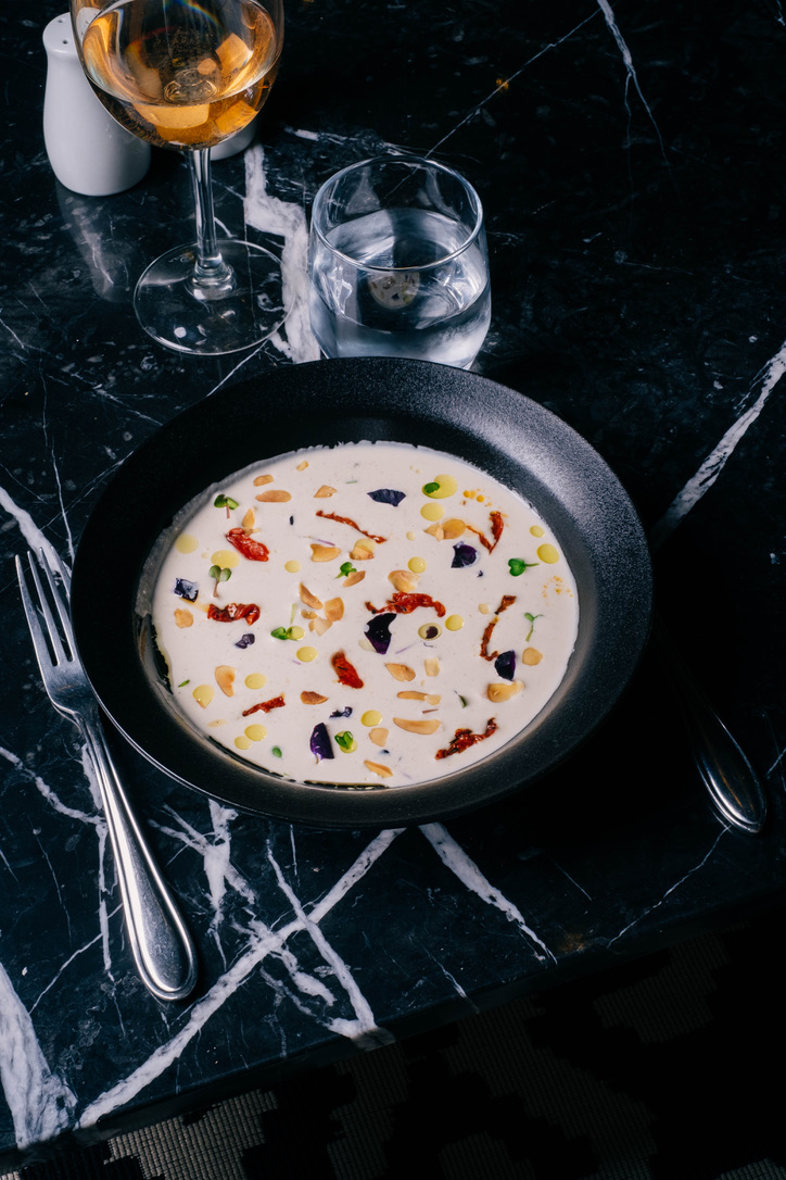 Comfortable seating area in a Moroccan riad with colorful patterned cushions against a backdrop of intricate zellige tiles, vibrant and detailed