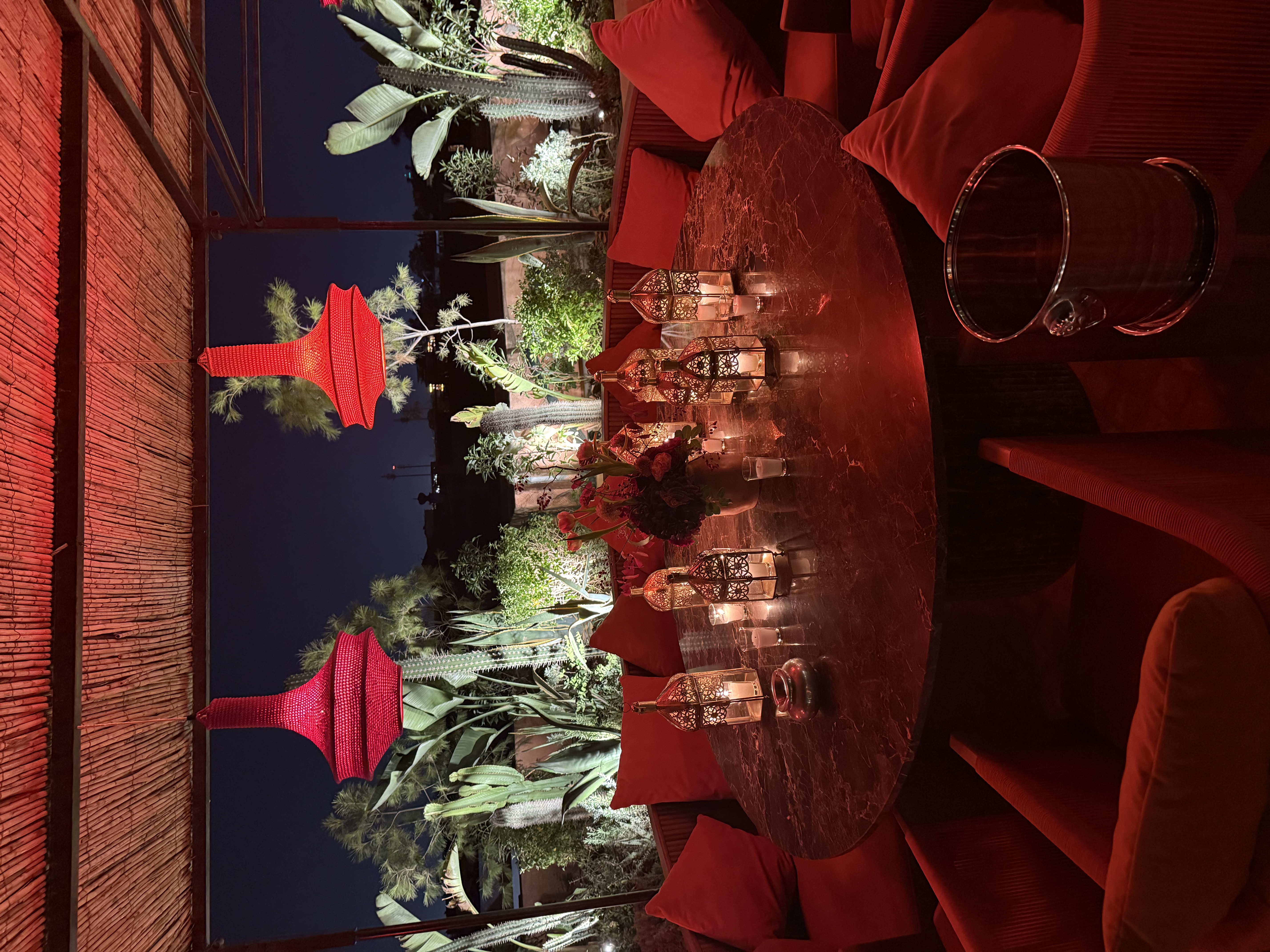 Bright and airy Mediterranean restaurant interior with white and blue decor, fresh flowers on tables, large windows with natural light, and a coastal vibe