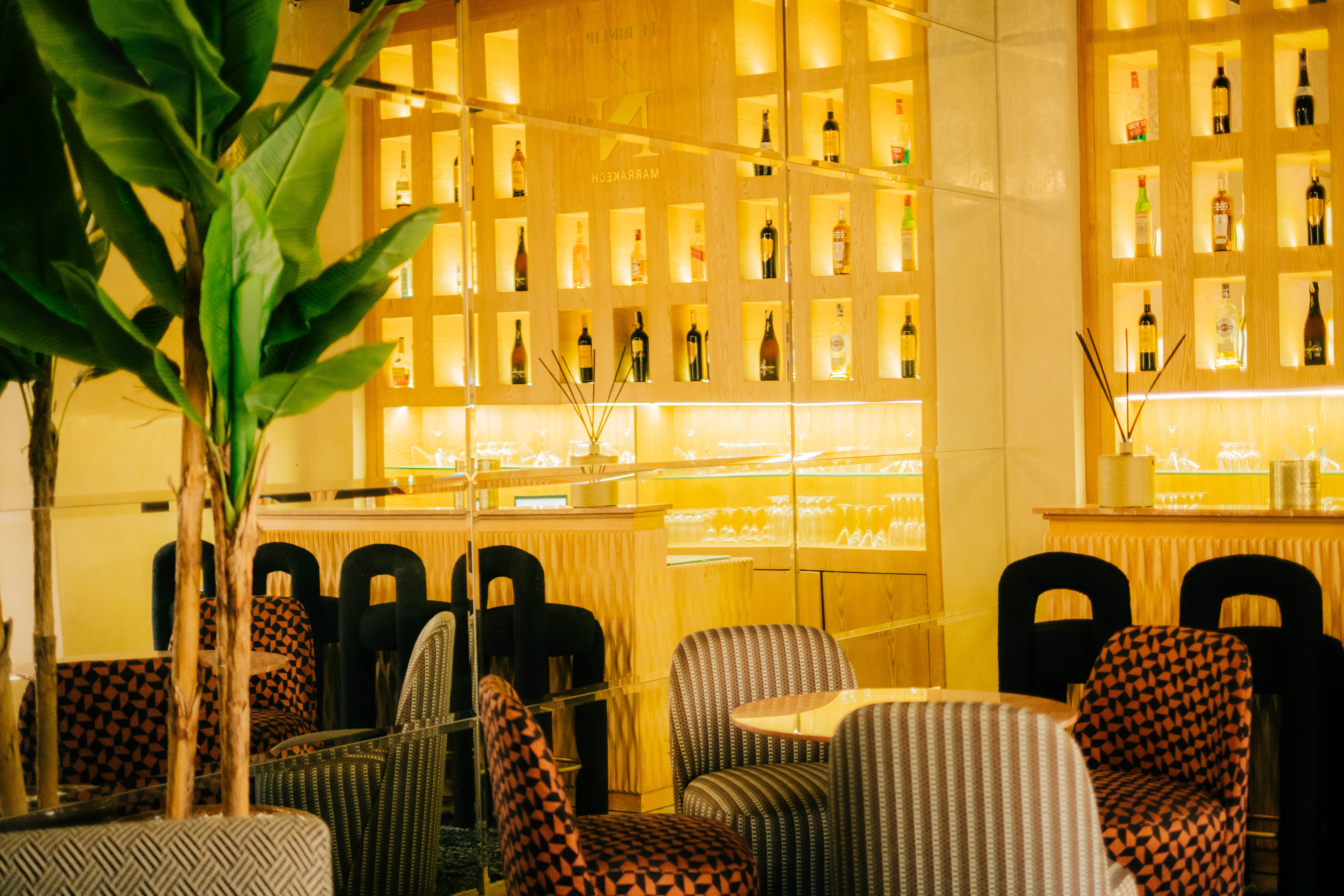 Cozy and sophisticated speakeasy bar with dark wood paneling, leather armchairs, a glowing bar with premium spirits, and intimate lighting, classic style