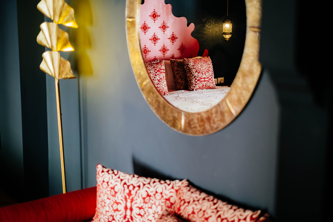 Cozy Moroccan comfort room at golden hour, warm ambient lighting, traditional decor, inviting atmosphere, luxury hotel photography