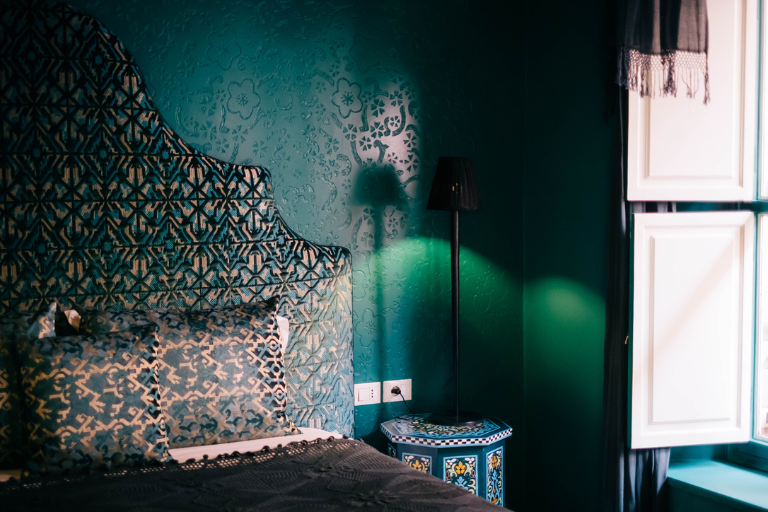 Rooftop dining setup at a Moroccan riad at dusk, with candlelight, white tablecloth, and city views, romantic and exclusive