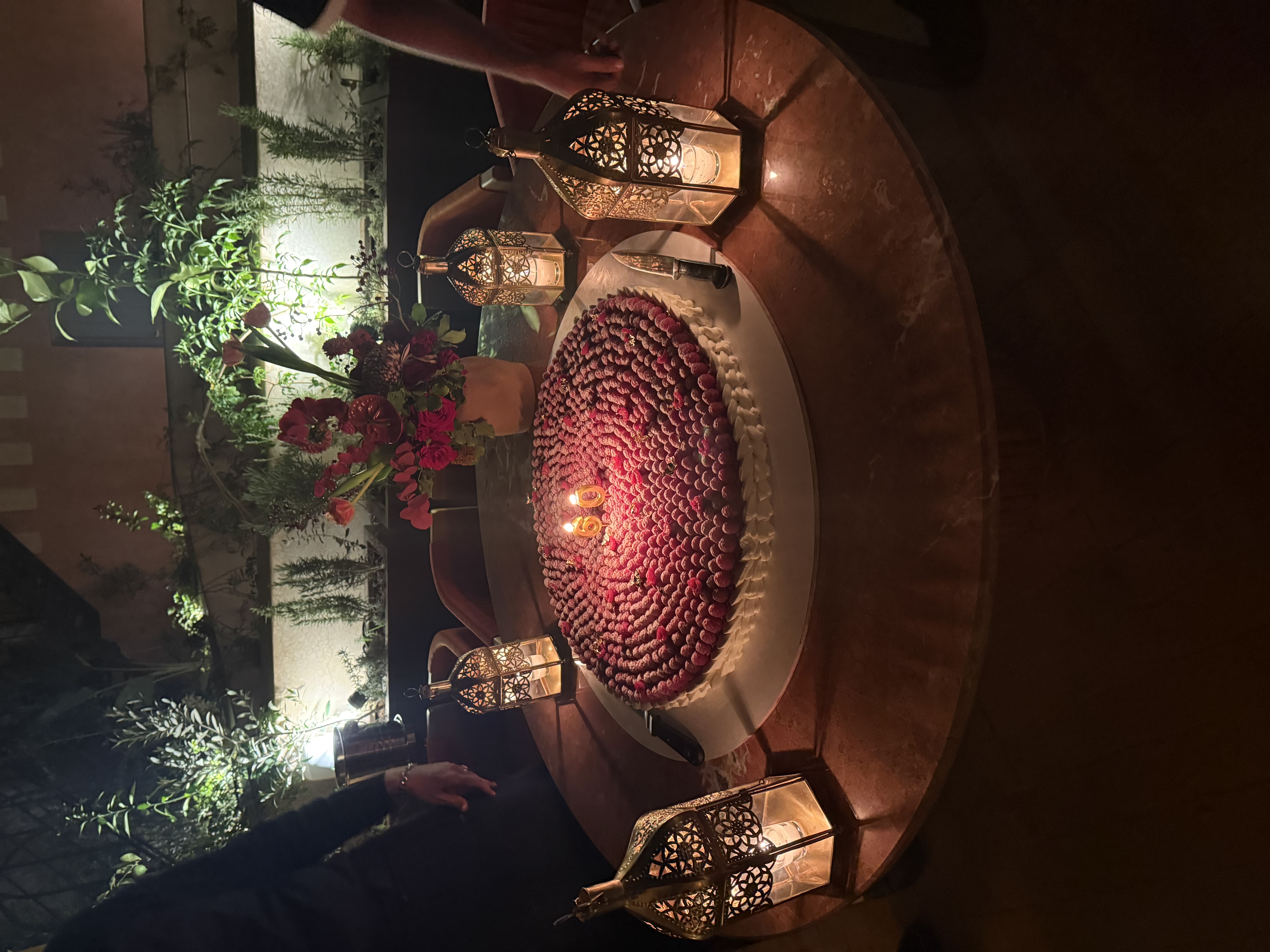 Terrasse romantique au coucher du soleil, table décorée, pétales de roses et vue sur les toits de la Médina
