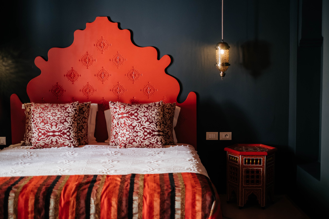 Luxurious Moroccan Riad interior with intricate zellige tilework, plush velvet seating, and warm ambient lighting, elegant style