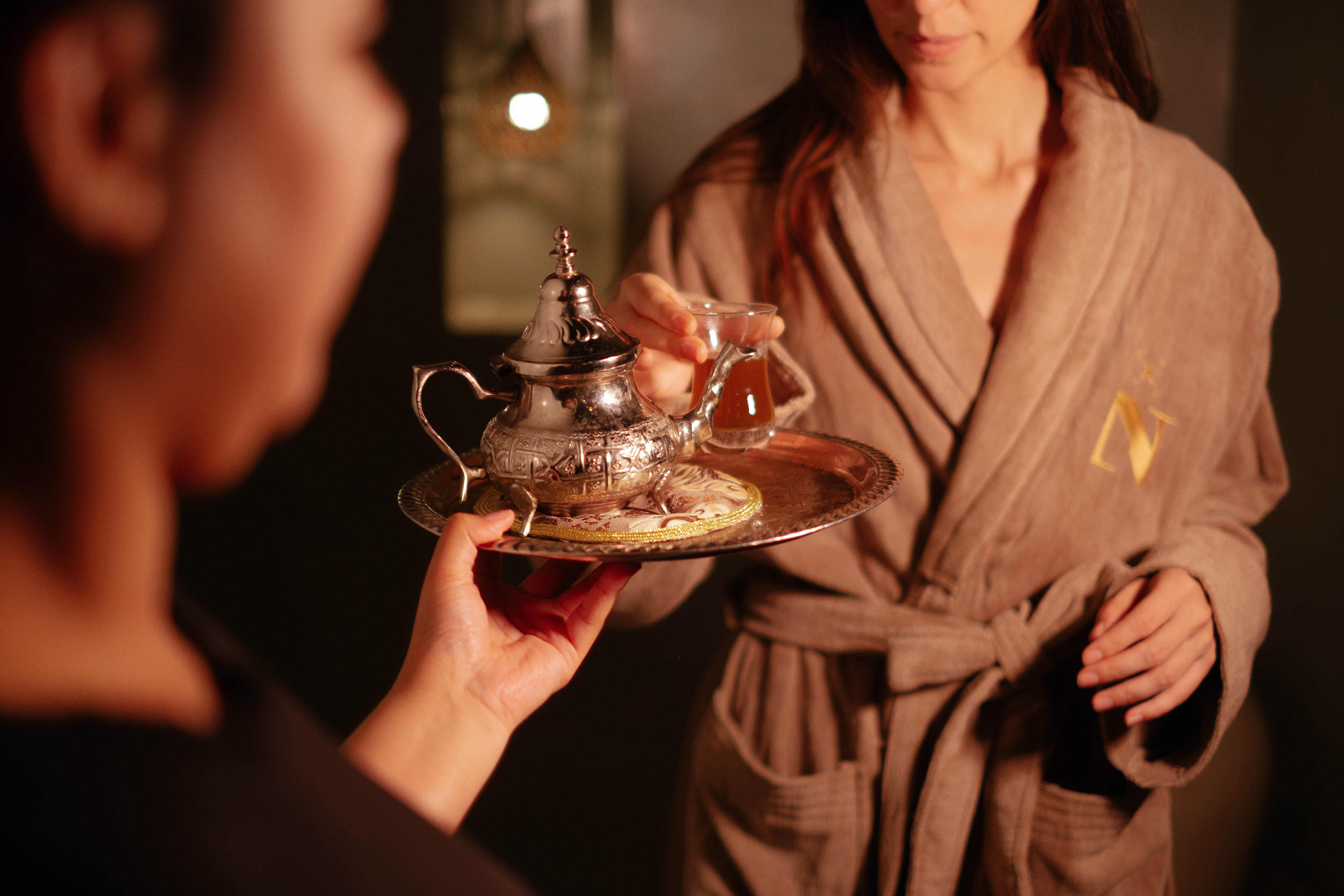 Elegant Moroccan bedroom with a four-poster bed, dark wood paneling, and sophisticated decor, warm and intimate