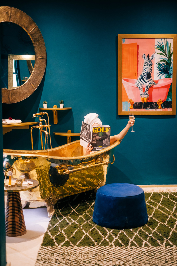 Dark and moody interior of a premier Moroccan riad suite, with intricate latticework, plush armchairs, and atmospheric lighting, sophisticated style